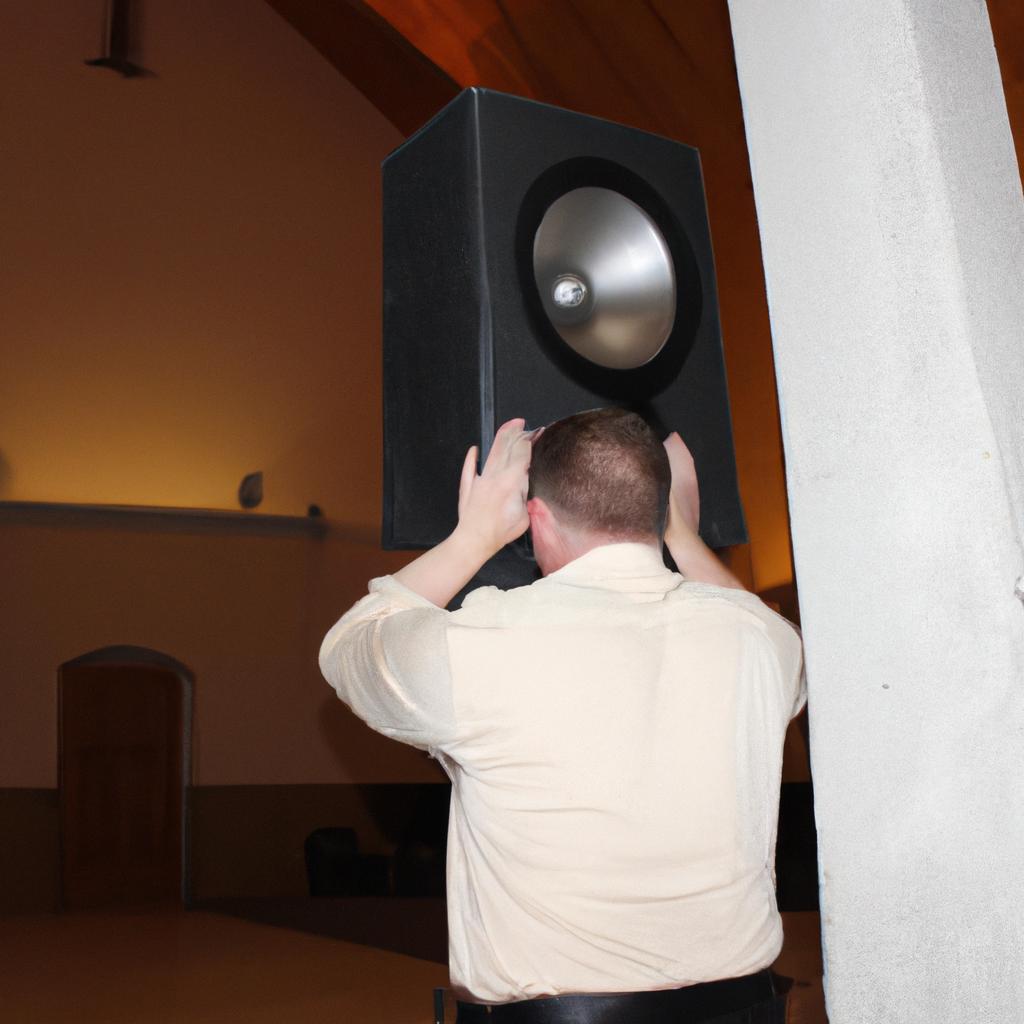 Person adjusting church sanctuary speakers
